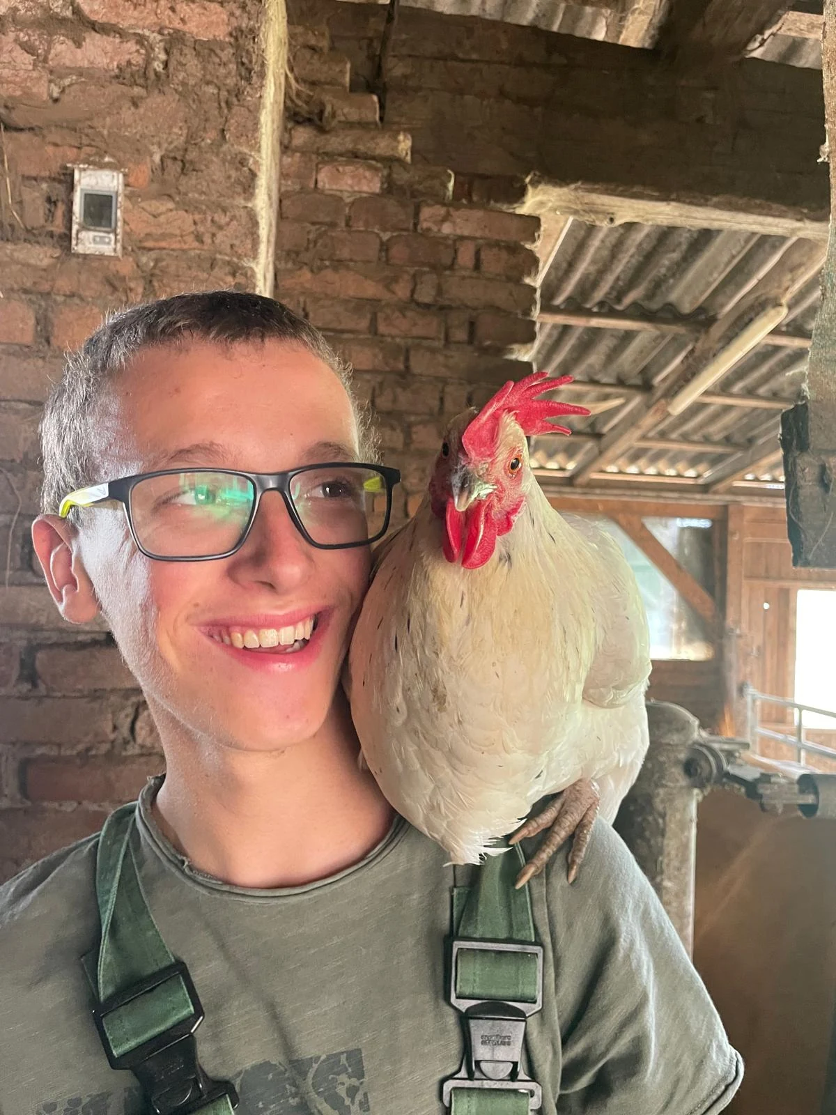 Klient des Qualifizierungs- und Übungsbauernhofs mit einem Huhn am Biohof Fritz